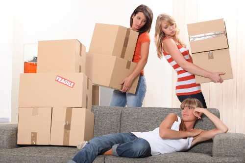 Furniture and boxes being moved through a Hornsey apartment building corridor